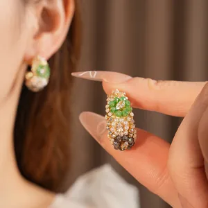 Vintage gold hoop earrings with emerald green beads and marquise rhinestones