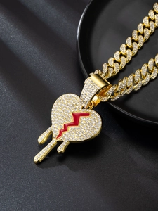 Gold Cuban link necklace featuring a crystal-encrusted bleeding heart pendant close-up