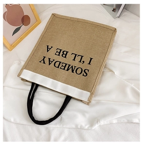 Detailed texture of ethnic linen tote bag featuring rope handles and printed text design