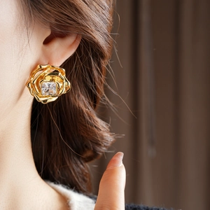 Détail d'une boucle d'oreille fleur plaquée or 18k ornée d'un zircon cubique brillant