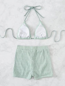 Detailed flat lay of mint green textured knit bikini set with high waist shorts