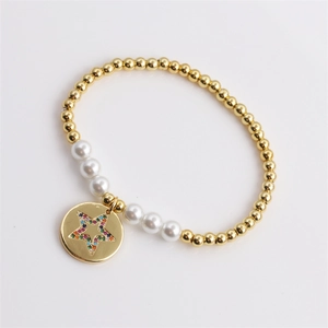 Close-up of pearl bead bracelet with a gold star pendant inlaid with colorful zircons