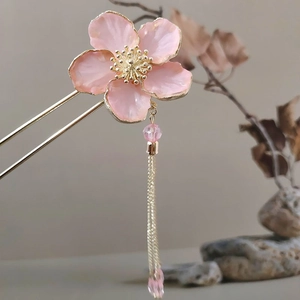 Detail of pink resin flower hair pin with golden tassels for traditional Hanfu styling