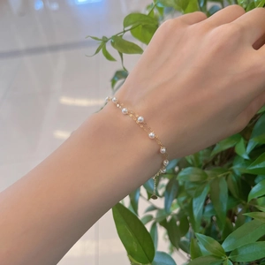 Elegant 18k gold double-layer bracelet with natural freshwater pearls on model's wrist