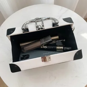 White suitcase-shaped handbag showing interior capacity for phone and cosmetics