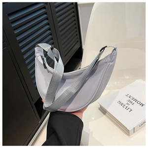 Detail view of the light gray nylon crescent bag with adjustable strap and zipper closure