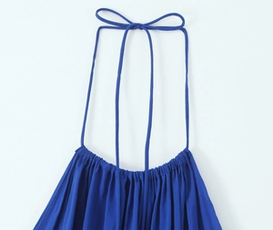 Close-up of the halter neck tie and pleated details on a royal blue midi dress