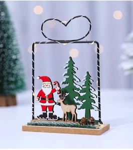 Detail of wooden Christmas night light featuring Santa, reindeer and pine cones