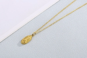 Vue détaillée d'un pendentif doré de la Vierge Marie avec une élégante chaîne en O