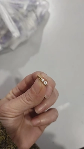 Macro close-up showing detail of golden U-shaped non-pierced nose clip with sparkling zircons