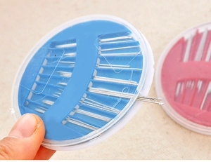 Detailed view of hand rotating the circular sewing needle case for easy access to needles