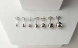 Détail de sept paires de boucles d'oreilles boules en acier inoxydable de tailles graduées