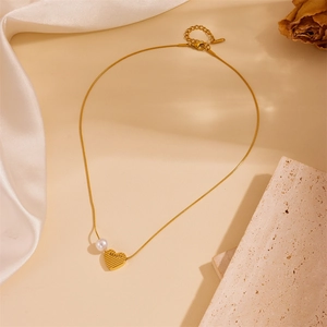 Elegant gold titanium necklace with a heart pendant, beauty engraving, and white pearl