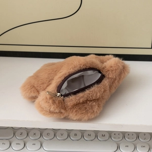 Vue détaillée du porte-monnaie en peluche camel avec fermeture éclair et doublure blanche