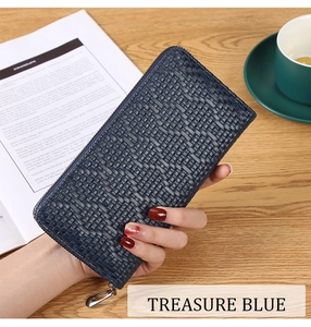 Treasure blue woven texture long wallet held over a wooden table and coffee cup