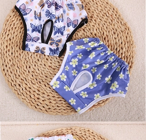 Detail view of cotton dog sanitary pants with blue floral and butterfly prints on straw mat