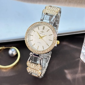 Détail d'une montre à quartz avec lunette sertie de diamants et bracelet métal bicolore