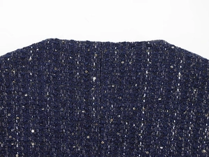 Detailaufnahme der blauen Tweed-Struktur mit glitzernden Pailletten und Kragen-Nähten