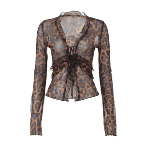 Detail of leopard print mesh top featuring a V-neck tie closure and delicate ruffle trim