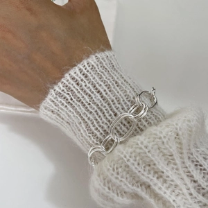 Polished 925 sterling silver chunky double-link chain bracelet on a white knit sleeve