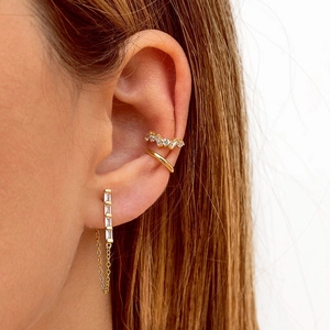 Close-up of gold tassel chain earrings and zircon ear cuff worn on the ear detail