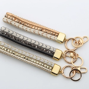 Braided leather wrist straps with gold and silver metal accents for keys and phones