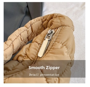 Detail of smooth silver zipper on khaki quilted nylon cloud bag with soft padding