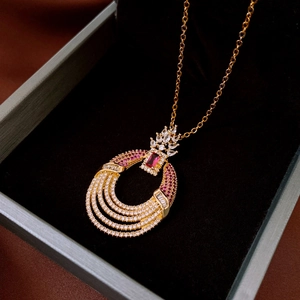 Detail of luxury gold necklace with layered rings, red gems and crystal inlay