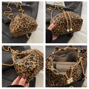 Detail view of leopard bucket bag interior pockets and elegant pearl chain strap