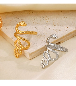 Detailed view of gold and silver snake rings with scale textures on silk background
