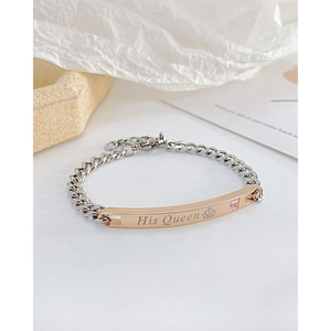 Macro detail of His Queen engraving on rose gold plate with pink stone and silver Cuban chain