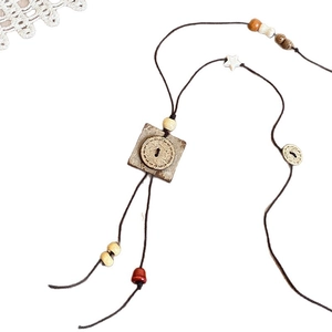Collana retrò fatta a mano con perle in legno e ciondolo in guscio di cocco su bianco