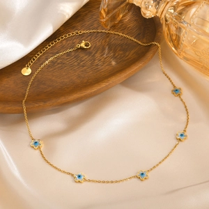 Close-up of gold stainless steel necklace with five blue enamel evil eye flower charms