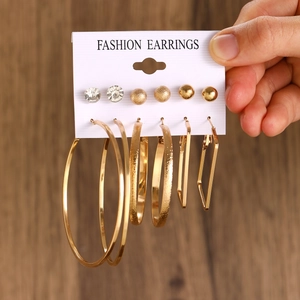 Detail view of 6-pair gold geometric earring set with pearls and rhinestones on a card