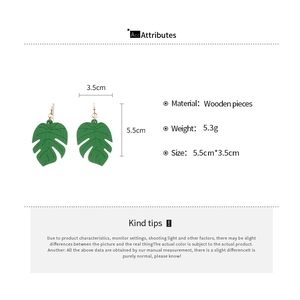 Detail view of green wooden leaf earrings showing 5.5cm by 3.5cm size and 5.3g weight specs