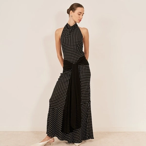 Detail of elegant black polka dot halter dress with open back and flowing waist tie