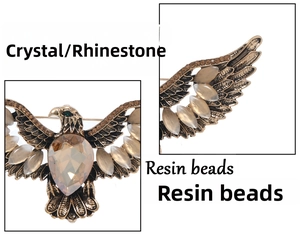 Detailed view of eagle brooch with rhinestone wings and faux cat-eye resin feathers