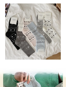 Detail of six pairs of heart pattern Fair Isle knit socks in black, pink, and grey shades