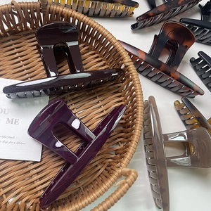 Elegant large butterfly hair claw clips in various colors displayed in a woven basket