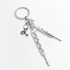 Detailed view of silver medical keychain with stethoscope, syringe, and thermometer charms