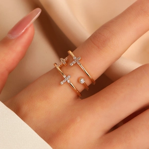 Macro shot of gold-tone cross ring with inlaid zircons on a soft satin background