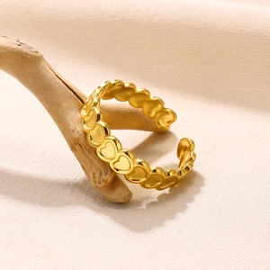 Detailed close-up of 18K gold heart-shaped ring displayed on a natural wooden branch