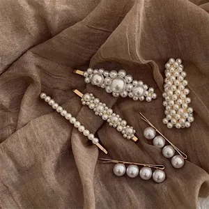 Baroque style pearl hair clips set with six different golden pins on a vintage fabric