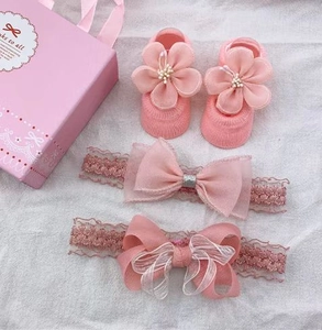 Detailed set of pink lace bow headbands and floral knitted baby socks for special occasions