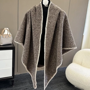 Detail showing soft dark brown knitted shawl with white stitching on high-quality fabric