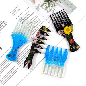 Close-up of DIY resin hair comb set with dried flowers and shimmering glitter details