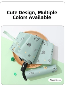 Detail of automatic green folding umbrella with cute cat paw patterns and matte handle
