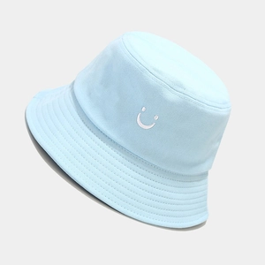 Close-up of light blue cotton bucket hat featuring white smiley face embroidery