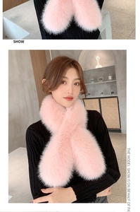 Close-up and fit of a soft pink faux fox fur cross-over scarf on a black knit sweater
