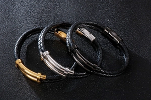 Détail de bracelets en cuir tressé double couche avec fermoirs magnétiques or, argent et noir